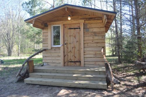KorjuseKorjuse Moori metsaonn- forest hut的木头屋,树林里有一扇门