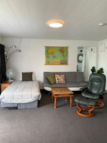 DinsdaleSmart Apartment的一间卧室配有一张床、一张沙发和一把椅子
