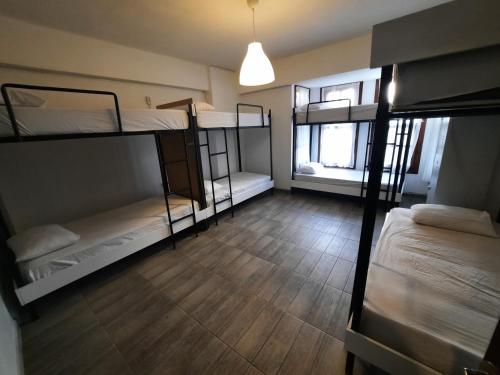 安塔利亚Kuyu Beergarden Hostel的客房设有三张双层床,铺有木地板。