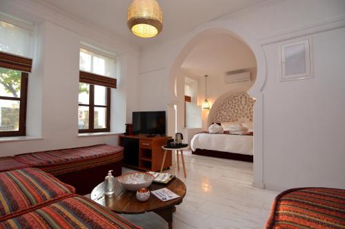 卡瓦拉Amina Hanem Boutique Apartments的客厅配有床、沙发和桌子