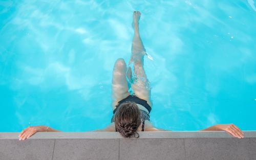 塞纳河畔罗米伊Nicey - Hôtel Spa, Lounge, Coworking的漂浮在游泳池中的女人