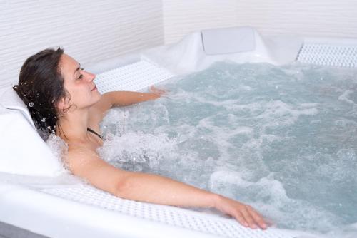 塞纳河畔罗米伊Nicey - Hôtel Spa, Lounge, Coworking的女人坐在浴缸里