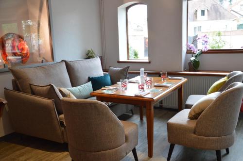 塞纳河畔罗米伊Nicey - Hôtel Spa, Lounge, Coworking的配有桌椅和沙发的房间