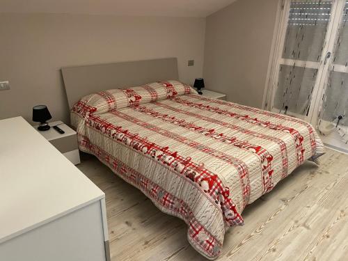 奥斯塔Appartements Chez Maghy的一间卧室配有一张带红色和白色棉被的床
