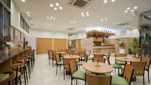 横滨Toyoko Inn Yokohama Tsurumi eki Higashi guchi的一间带桌椅和柜台的餐厅