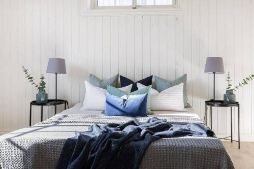 利勒哈默尔Lys og sentral leilighet med terrasse og hage的一间卧室配有一张带蓝色和白色枕头的床