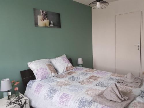 弗勒里莱欧布赖Superbe appartement de 41m2 en résidence privé的一间卧室配有一张带紫色和白色棉被的床