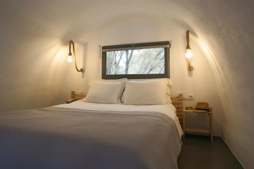 佩里萨Exi Sea Side Suites的一间卧室配有一张带白色床单的床和一扇窗户。