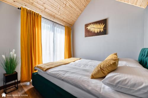 索斯诺夫卡Green Fields village的一间卧室设有一张床和一个大窗户