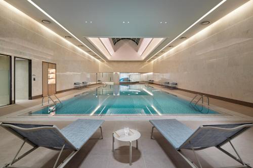 首尔乐天世界酒店的大楼内带桌椅的大型游泳池