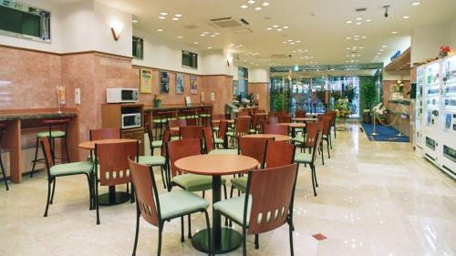 川崎Toyoko Inn Kawasaki Ekimae Shiyakusho-dori的餐厅内带桌椅的用餐室