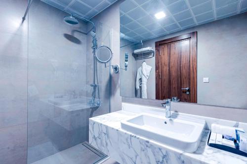 麦地那Mysk Touch Al Balad的一间带水槽、镜子和淋浴的浴室