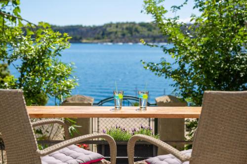 奥米沙利Holiday house SEAFRONT的一张桌子,上面放着两杯,享有水景