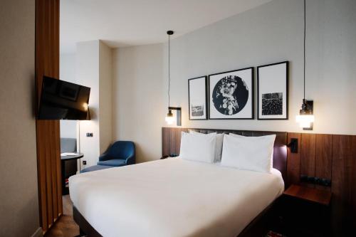泰拉维Holiday Inn Telavi, an IHG Hotel的酒店客房配有白色的床和蓝色椅子