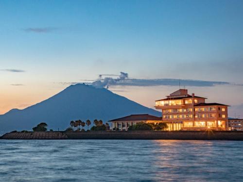 TarumizuLiVEMAX RESORT Sakurajima Sea Front的一座大建筑,背景是一座山