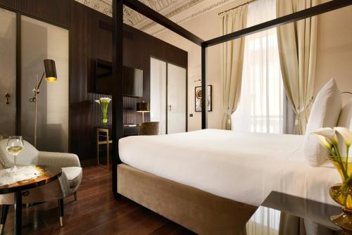 罗马Hotel L'Orologio Roma - WTB Hotels的酒店客房设有一张白色大床和一张桌子。