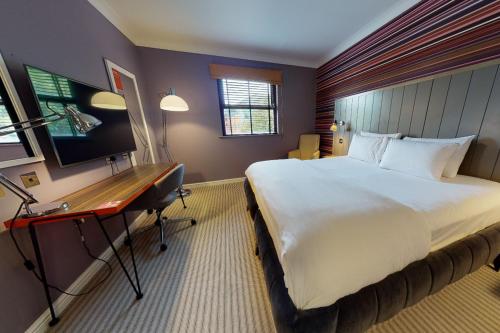 加登城切斯特圣大卫乡村酒店的酒店客房设有一张大床和一张书桌。