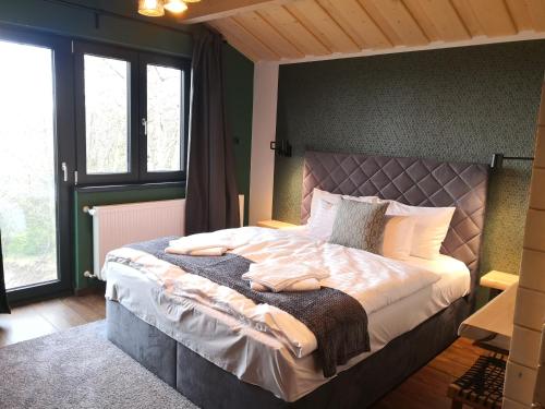 MatraszentlaszloWood Villa Mátra的一间带一张大床的卧室,位于带窗户的房间内