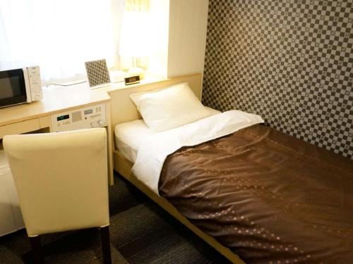 京都HOTEL LiVEMAX Kyoto Gojo的小房间设有床铺和微波炉