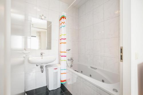 布雷斯肯斯Hello Zeeland - Appartement Port Scaldis 13-112的白色的浴室设有水槽和浴缸。
