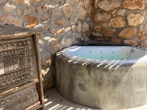 泰拉西尼Container Suite的石头房设有浴缸,配有石墙