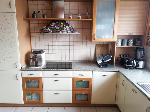 华沙Feels Like Home Metro Zacisze的厨房配有白色橱柜和炉灶烤箱。
