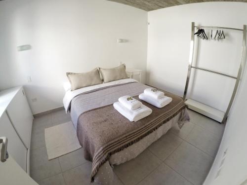 玛德琳港Departamentos Las Tablas的一间卧室配有一张床,上面有两条毛巾