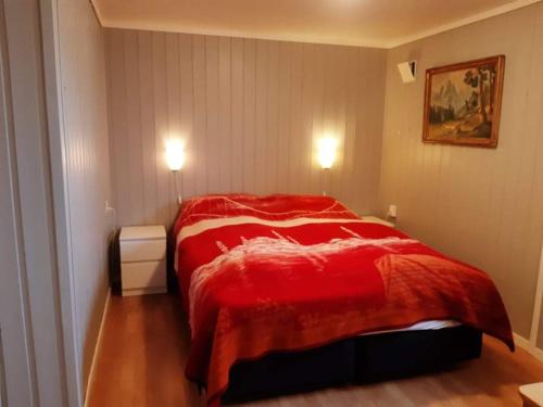 RøyrvikFjord side apartment的一间在房间内配有红色床的卧室