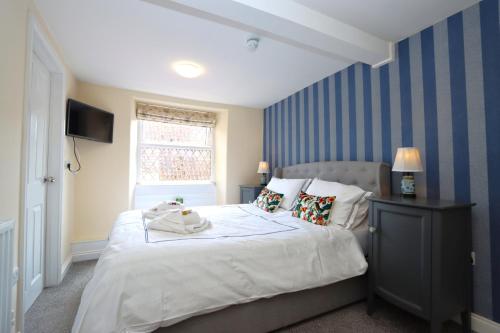 WellingoreThe Little Lion Inn, Red Lion的一间卧室设有一张带蓝色条纹墙的大床