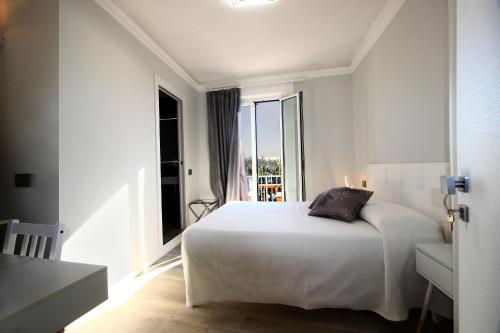 努马纳Affittacamere dei desideri的卧室设有白色的床和大窗户