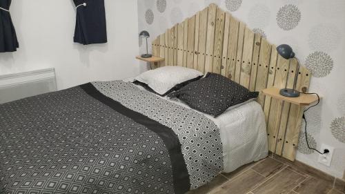 蓬托尔松Les Fauvettes的一间卧室配有一张带木制床头板的床