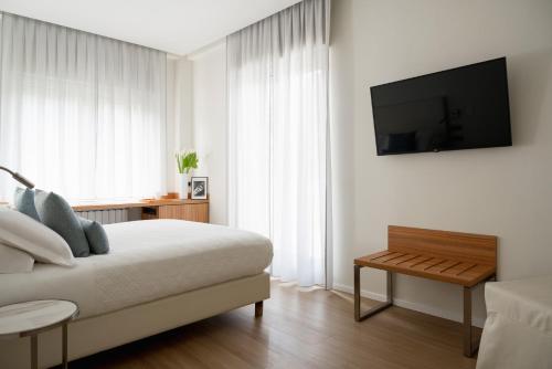 莱里奇多利亚公园酒店的一间卧室配有一张床,墙上配有电视