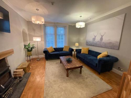德里门Elmbank Stay - Drymen的客厅配有2张蓝色沙发和1张咖啡桌