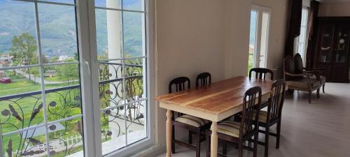 特拉布宗Vİlla DEVOR的一间带桌椅和大窗户的用餐室
