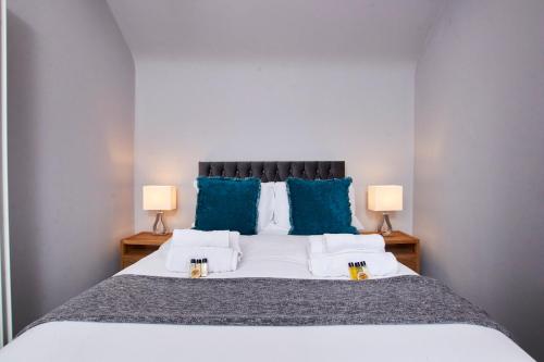 达宁顿堡Delven House, Apartment 6的一间卧室配有一张带蓝色枕头的大床
