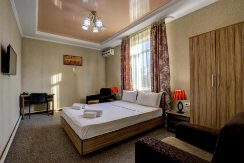 比什凯克Kausar Hotel的配有一张床和一把椅子的酒店客房