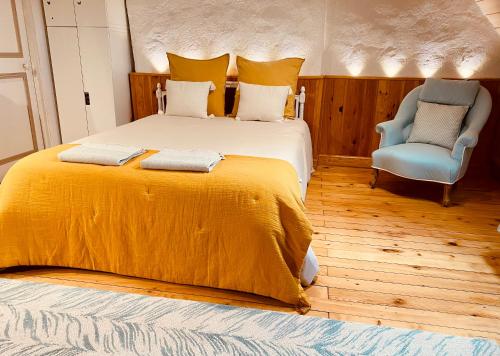 沙托鲁La maison de Montaboulin的一间卧室配有一张大床和一张蓝色椅子