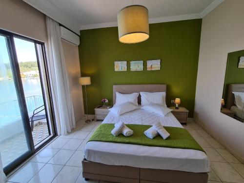 萨索斯Kikis house的一间拥有绿色墙壁的卧室和一张带毛巾的床