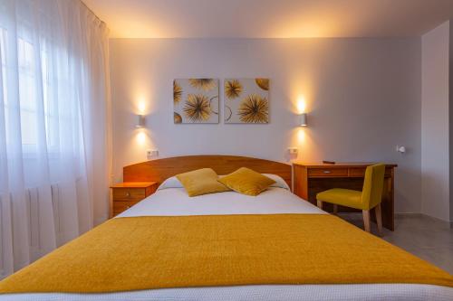 塞埃佩雷林尼亚酒店的一间卧室配有一张大床、一张桌子和一把椅子