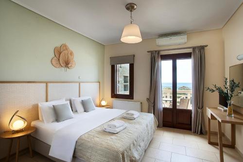 加夫里翁Aithra -Agios Petros Andros的卧室设有一张白色大床和一扇窗户。