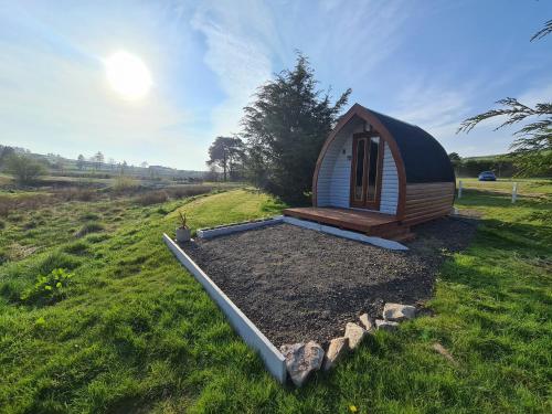 DerwenDelightful Camping Pod in Snowdonia, North Wales.的田间中的小小屋