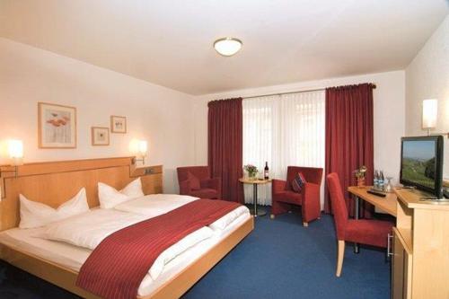 恩茨河畔法伊欣根卡切洛法旅馆的酒店客房配有一张床、一张书桌和一台电视。