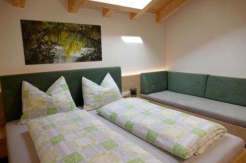 马伦格Der Luemerhof的一间卧室配有两张床和一张带枕头的沙发。