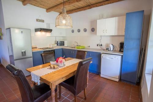 蒙塔古Harmonie Farm Cottages的厨房配有木桌和蓝色橱柜。