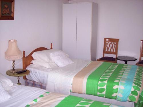 奇德尔蝴蝶旅馆的一间卧室配有两张床和一张桌子及椅子