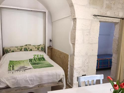 奥斯图尼casa anna的一间卧室设有一张床和石墙