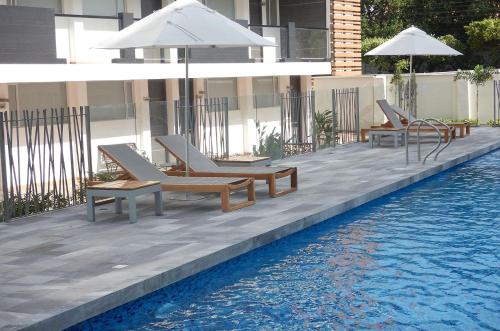 库库塔库库塔卡萨布兰卡酒店的一组椅子和遮阳伞,位于游泳池旁