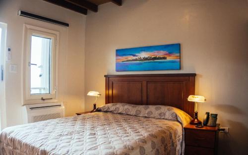 温沃德赛德Saba Arawak Hotel的卧室配有一张床,墙上挂有绘画作品