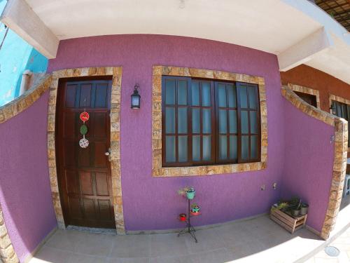 里约达欧特拉斯Vila da Drika的一座带紫色墙壁和两扇门的房子