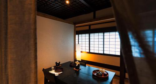 松本泉屋森贝酒店的一间带桌子和窗户的用餐室